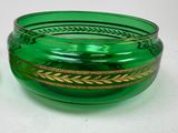 a green glass bowl with a gold decoration on it