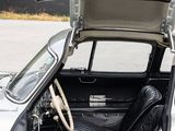 a silver car with its door open sitting in a parking lot