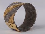 a close up of a metal bracelet with a gold clasp