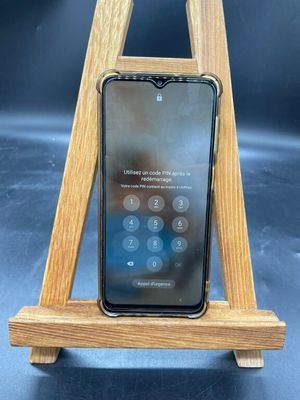 un support en bois pour téléphone sur lequel est posé un téléphone