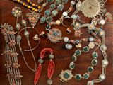 a wooden table topped with lots of assorted jewelry on top of it