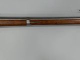 un vieux fusil accroché au mur à côté d'un couteau