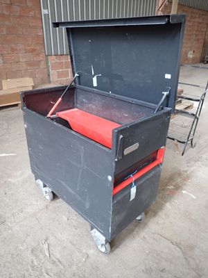 a black tool box with a red seat on wheels