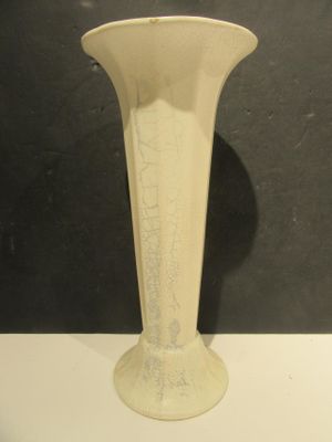 a white vase sitting on a table with a black background