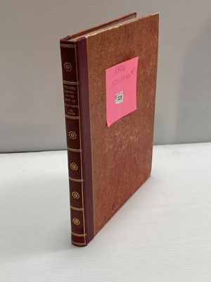 un vieux livre sur lequel est collé un autocollant rose, posé sur une table