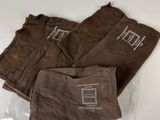 three pairs of brown pants sitting on top of a plastic bag