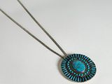 a close up of a necklace on a white surface