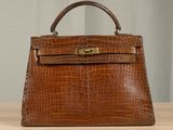 an image of a brown leather handbag sitting on top of a wooden table