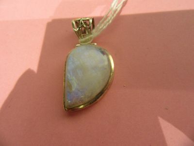 yellow gold plated pendant with a white opalite stone on a pink background