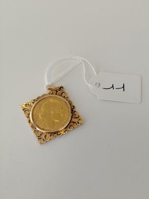 a gold coin with a tag on it sitting on a white surface