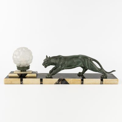 une sculpture Art déco représentant une panthère posée sur un socle en marbre et surmontée d'une lampe