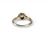 a close up of a gold ring with a white diamond