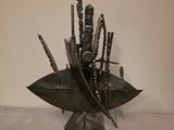 une sculpture représentant un bouquet de couteaux posé sur une feuille