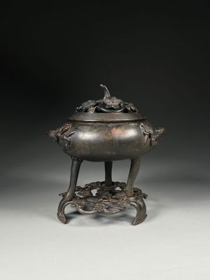 an image of a bronze incense pot on a stand on a white surface