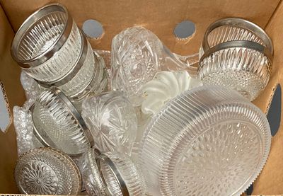 a cardboard box filled with glass dishes and cups