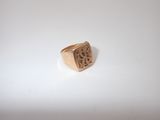 a close up of a gold signet ring on a white surface