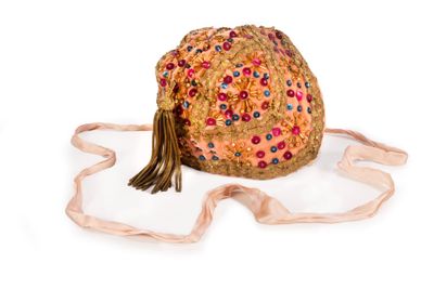 a small bag with a tassel on it on a white surface