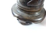 a bronze vase with a bird on top of it