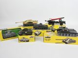 Plusieurs véhicules militaires miniatures sont alignés sur une surface blanche