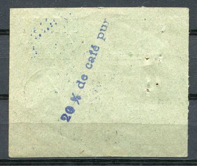 un vieux timbre sur lequel figure une inscription bleue, posé sur un morceau de papier