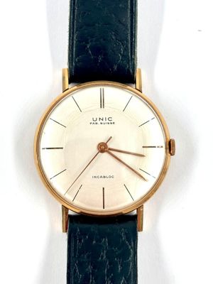 a close up of a watch on a white surface