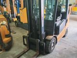 a forklift in a warehouse with other forklifts in the background