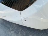 a close up of a white car with scratches on it