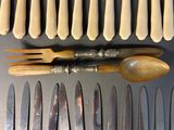 a lot of knives and spoons that are on the table