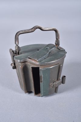 a small metal container with a handle on a white surface