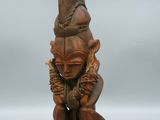 une vieille statue en bois d'un homme avec un chapeau sur la tête