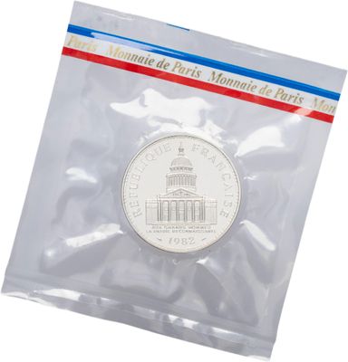 a close up of a coin in a plastic bag on a white background