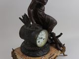 a statue of a woman sitting on top of a clock
