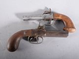 un vieux pistolet avec une poignée en bois sur une surface blanche
