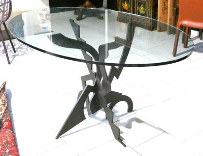 a glass table with a metal base on a tile floor