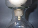 a glass vase with a white candle inside of it