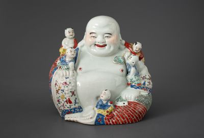 une statue représentant un Bouddha souriant avec un oiseau posé sur son bras