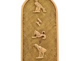 un pendentif plaqué or sur lequel figure une inscription égyptienne