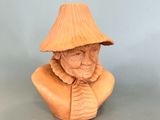 wooden bust of an old man with a hat on his head