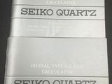 two manuals for seiko quartz and seiko quartz on a black surface