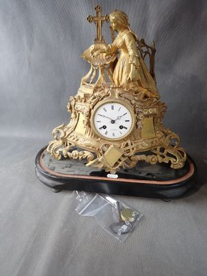 a gold clock sitting on top of a black table