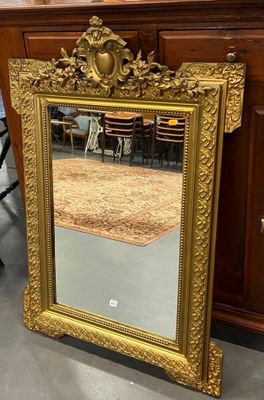 un miroir posé sur le sol devant une commode
