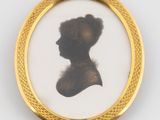 an antique photo of a woman in profile in a gold frame