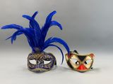 deux masques de bal masqué ornés de plumes bleues sur fond blanc