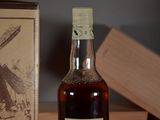 a bottle of whiskey sitting on a table next to a box