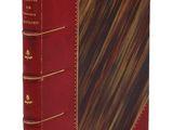 un vieux livre avec une couverture rouge et des bordures dorées sur fond blanc
