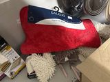 a red, white and blue towel and a mop on a shelf