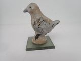 un petit oiseau perché au sommet d'un socle