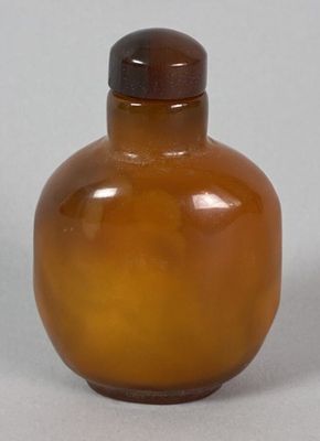 a brown glass bottle with a brown lid on a table