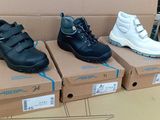 trois paires de chaussures pour enfants dans des boîtes posées sur une table