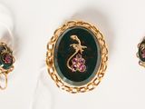 a close up of a necklace and earrings with a dragon on it